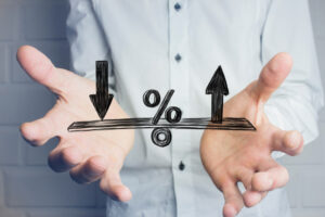 Blog Angrynomics: Image of an interest rate "teeter totter" in front of the image of a person's torso